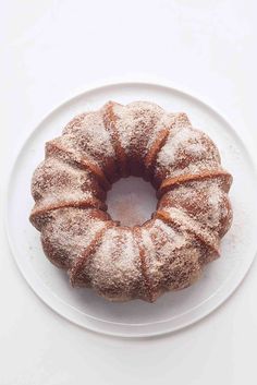 a bundt cake sitting on top of a white plate covered in powdered sugar