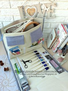 an assortment of crafting supplies sitting on top of a table next to a white brick wall