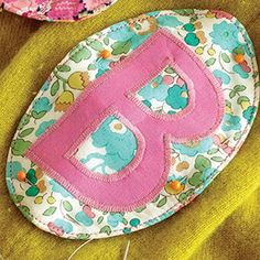 a close up of a flowered rock with the letter d on it and a pair of scissors next to it