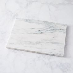 a white marble cutting board sitting on top of a counter