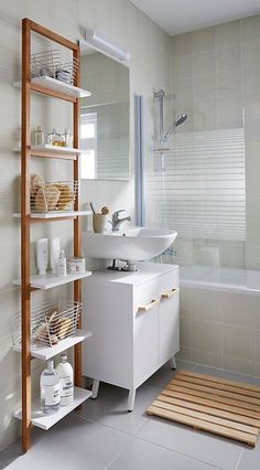 a bathroom with white tile and wooden shelves