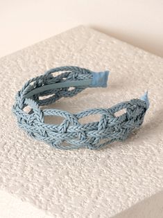 a close up of a blue bracelet on a white surface