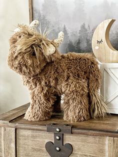 a stuffed animal sitting on top of a wooden chest