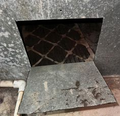 the inside of a cement wall with a metal grate on it's side