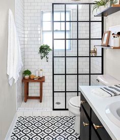 a white bathroom with black and white tile