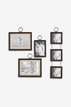 four black and white frames hanging on the wall with pictures attached to it's sides