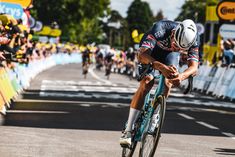 a bicyclist is racing down the road in front of a large crowd