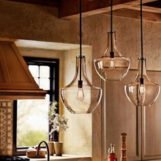 three light fixtures hanging from the ceiling in a kitchen