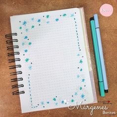 a notebook with blue snowflakes on it next to a pen