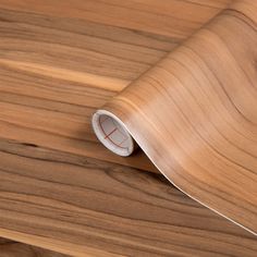 a close up of a wooden surface with a roll of paper