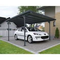 a white car parked under a metal carport in front of a house on a driveway