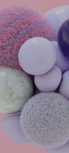 several different colored balloons and rocks on a pink background