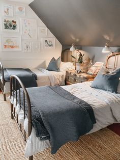 two beds in a room with pictures on the wall and carpeted floor, next to each other