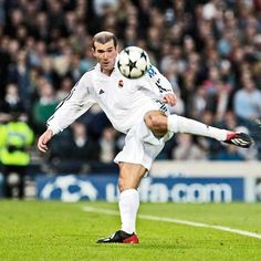 a man kicking a soccer ball on top of a field