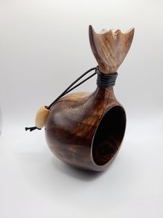 a small wooden vase sitting on top of a white table