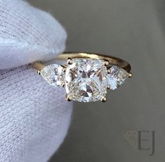 three stone diamond ring on white fabric