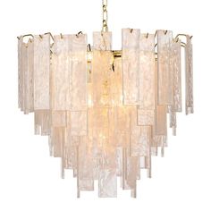 a large chandelier made out of glass blocks and gold metal fittings, hanging from a chain