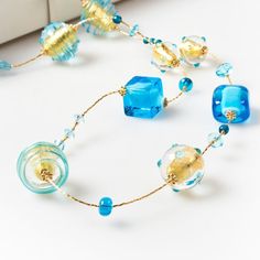 "Length: 88 cm / 34,64 \" Weight: 100 gr / 0,22 lb Classic tradition of this necklace is captured by the unique beads of different shapes: a succession of aquamarine glass squared and rounded beads, covered by precious gold leaf and \"sommerso\" in crystal, alternating with small spheres. The modern touch is given by the small crystals framing each bead, giving them additional light. This necklace, with its bright colours, is perfect for any style and fashion: its light composition makes it the Turquoise Glass Necklace For Party, Turquoise Glass Necklaces For Party, Long Glass Beaded Chain Necklace, Party Necklace With Large Glass Beads, Elegant Turquoise Glass Beaded Necklace, Long Glass Beaded Necklace For Party, Modern Polished Beads Necklace For Gift, Long Glass Beaded Necklaces For Party, Turquoise Glass Party Necklace