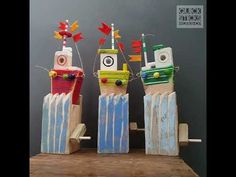 three wooden toy boats sitting on top of a wooden table in front of a gray wall