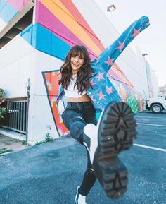 a woman is posing with her foot in the air while holding onto a skateboard