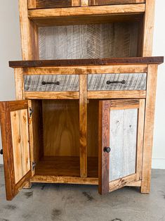 a wooden cabinet with two doors and drawers on the bottom, one door is open