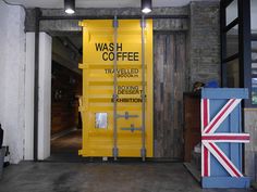 there is a yellow sign that says wash co - coffee on the door and next to it is a british flag