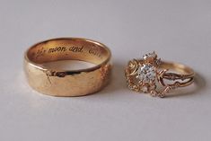 two gold wedding rings sitting next to each other