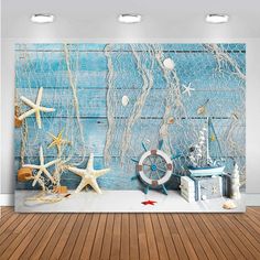 an ocean scene with starfish, shells and other items on a wooden floor in front of a blue wall