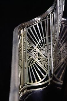 an intricately designed metal stair railing against a black background