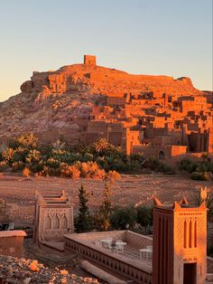 an old village in the desert with mountains in the background