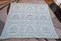 a white crocheted blanket sitting on top of a rug