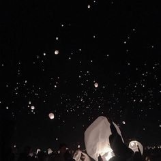 the sky is filled with many floating lanterns