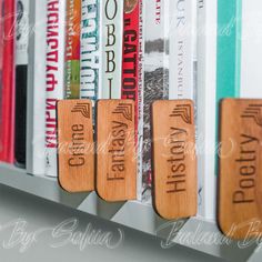 three wooden bookmarks that are sitting on a bookshelf