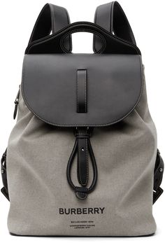 Cotton canvas backpack in grey. Buffed calfskin trim in black throughout. Integrated carry handle at top. Twin adjustable leather shoulder straps. Logo bonded in black at face. Zippered pocket at side. Mesh panel in black at back face. Foldover flap with press-stud fastening. Drawstring at throat. Zippered pocket, patch pocket, and embossed logo at interior. Cotton and linen-blend canvas lining in beige. Silver-tone hardware. Approx. 12.5 length x 17 height x 5.75 width. Supplier color: Black Burberry Backpack Men, Burberry Mens Bag, Burberry Clothing, Burberry For Men, Burberry Outfit, Canvas Backpack, Burberry Men, Mesh Panel, Press Studs