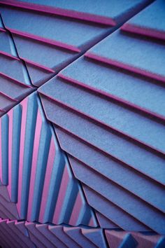 an abstract background with pink and blue lines in the center, on top of a wall