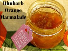 a jar filled with orange marmalade sitting on top of a colorful table cloth