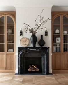 a living room filled with furniture and a fire place in front of a bookcase