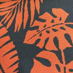 an orange and black tropical print fabric with palm leaves on the bottom half of it