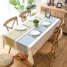 a dining room table set with plates and place settings