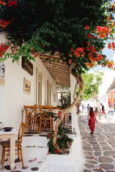 a woman in a red dress is walking down the street