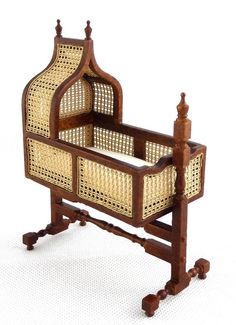 an antique wooden cradle with wicker baskets on it's sides and legs, against a white background