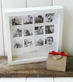 a wooden box with a red ribbon around it next to a white framed photo on a shelf