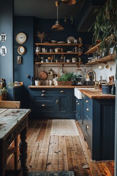 a kitchen with blue walls and wooden floors is pictured in this image, there are clocks on the wall