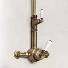 an antique brass faucet with two white lights on the side and a wall