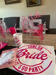 the table is set up for a bridal party with plastic cups and napkins