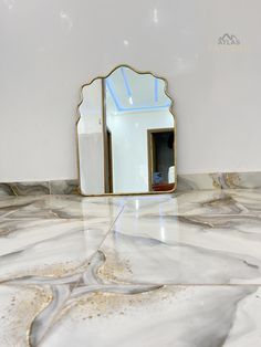 a mirror sitting on top of a marble counter