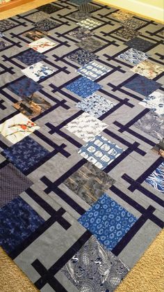 a large blue and gray patchwork quilt on the floor in front of a door