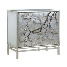 a mirrored cabinet with branches painted on the front and bottom, sitting against a white background