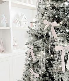 a decorated christmas tree with pink bows