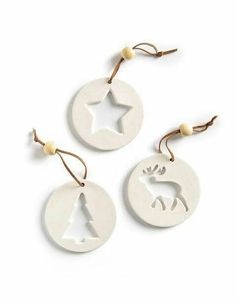 three white ornaments with deer and star on them